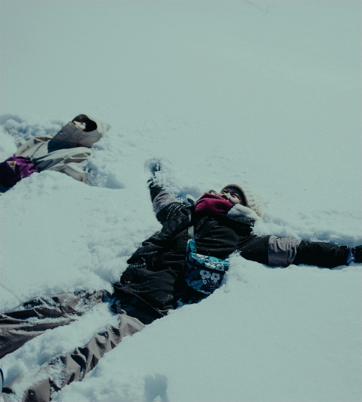 雪に横たわる2人